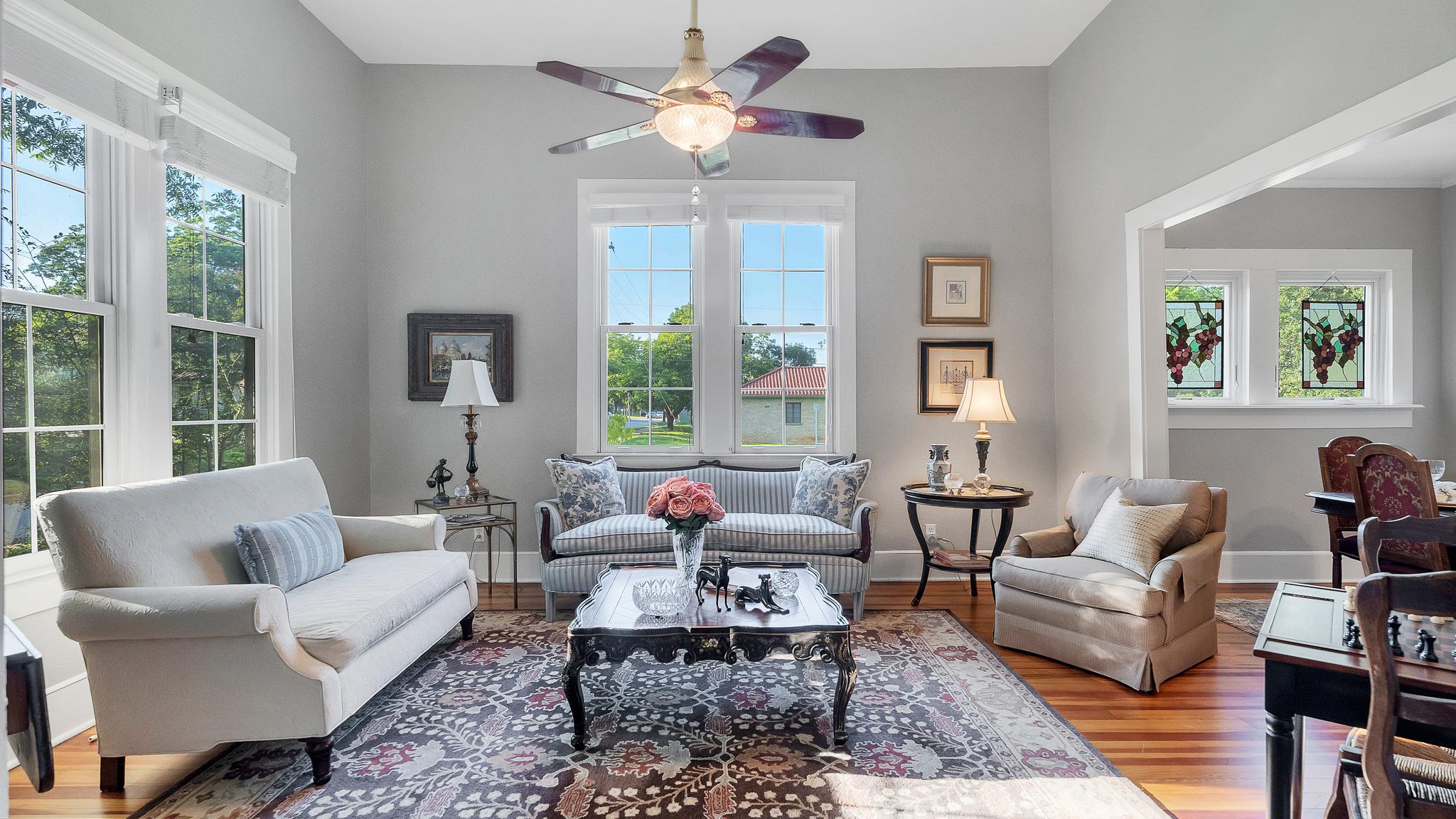 Living room photo with hardwood floors and tall windows at 1305 S College St Georgetown Texas
