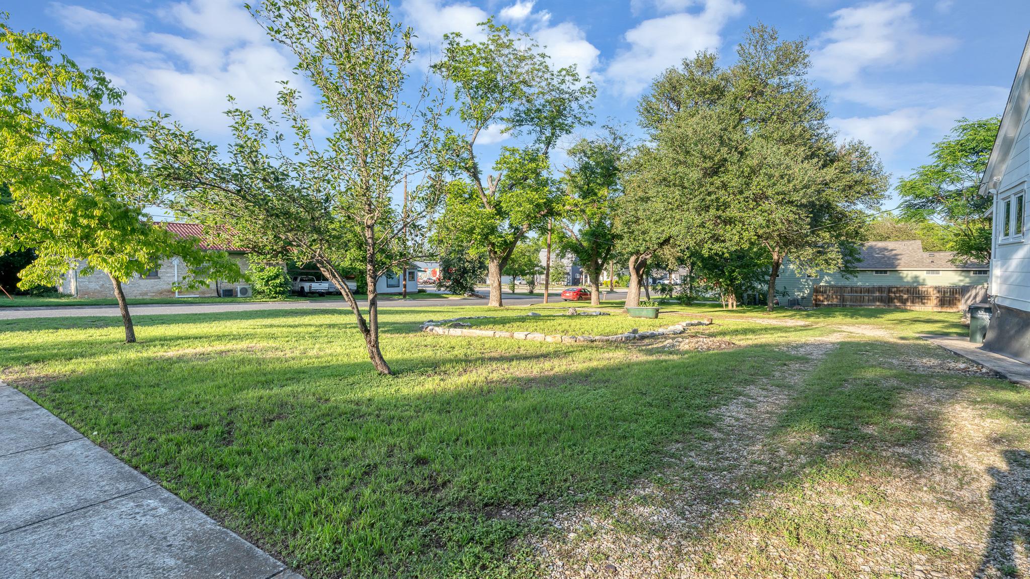 Exterior photo highlighting the yard and mature trees at 1301 and 1305 S College St